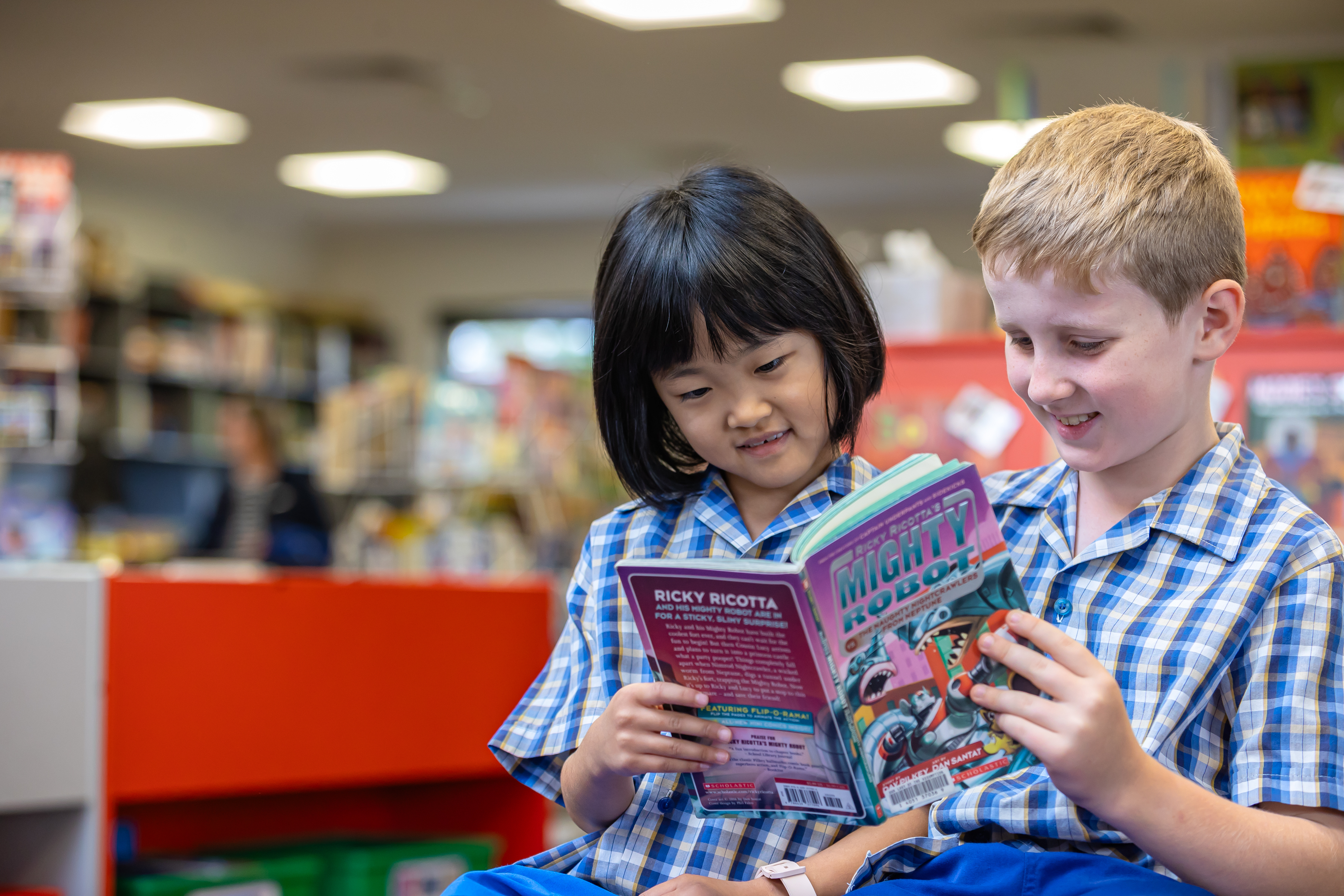Students reading books together in a school library during a quiet learning activity